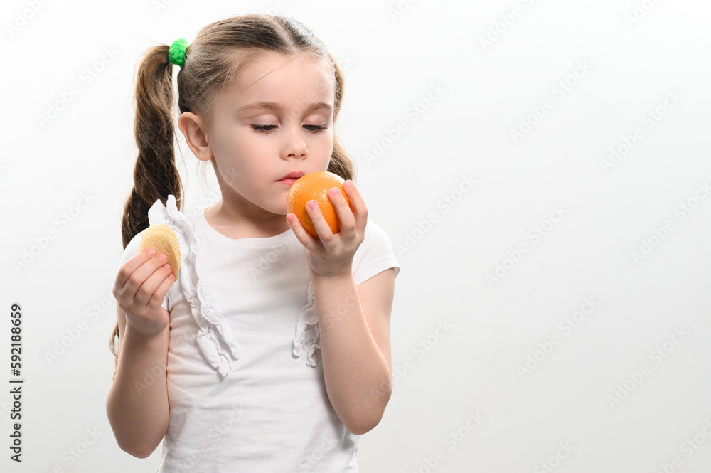 Tangerines and chips, healthy and harmful, a girl with a tangerine and chips in her hands on a white background. Tangerines and chips, healthy and harmful, a girl with a tangerine and chips in her hands on a white background.