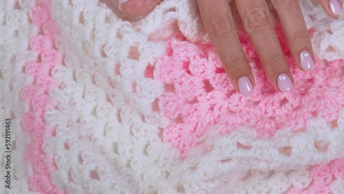 Close-up top view 4k video footage of elegant female hand with elegant mainted pink nails isolated on white and pink background. Naildesign with cute white hearts to Valentine's day, wedding design photo