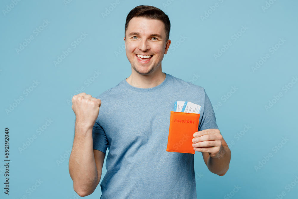 Traveler fun woman wear casual clothes hold passport ticket do winner gesture isolated on plain blue background. Tourist travel abroad in free spare time rest getaway. Air flight trip journey concept. Traveler fun woman wear casual clothes hold passport ticket do winner gesture isolated on plain blue background. Tourist travel abroad in free spare time rest getaway. Air flight trip journey concept.