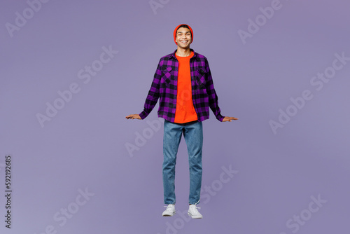 Full body fun young man of African American ethnicity wear casual shirt orange hat jump high pov flying levitating look camera isolated on plain pastel light purple color background studio portrait.
