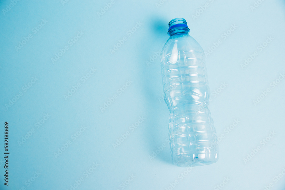 Transparent plastic bottle on the blue background. Concept of earth day, zero waste and plastic recycling. Transparent plastic bottle on the blue background. Concept of earth day, zero waste and plastic recycling.