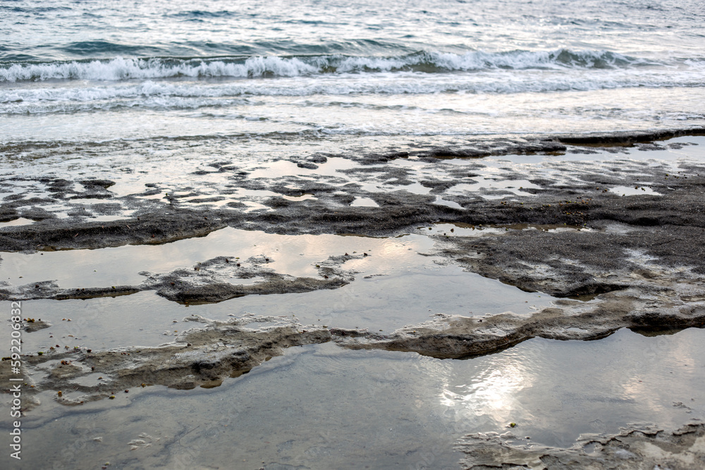 Wet sand on the beach with water reflection. Natural background.