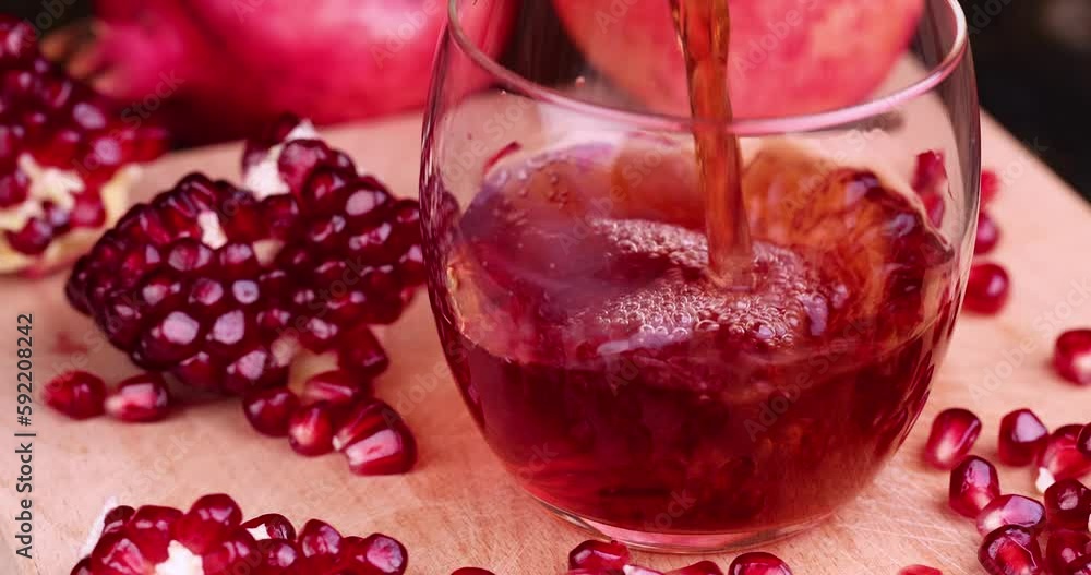 Red freshly squeezed pomegranate juice in a transparent glass, poured into a glass glass sweet and sour pomegranate juice Red freshly squeezed pomegranate juice in a transparent glass, poured into a glass glass sweet and sour pomegranate juice