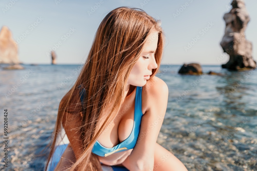 Woman sea sup. Close up portrait of happy young caucasian woman with long hair looking at camera and smiling. Cute woman portrait in a blue bikini posing on sup board in the sea Woman sea sup. Close up portrait of happy young caucasian woman with long hair looking at camera and smiling. Cute woman portrait in a blue bikini posing on sup board in the sea