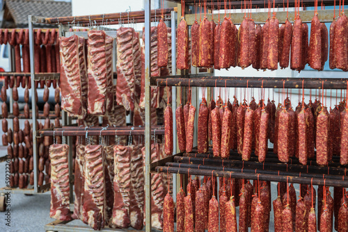 Drying saussages and bacons in the traditional method by hanging meat products outside for natural air drying in Grisons, Switzerland photo