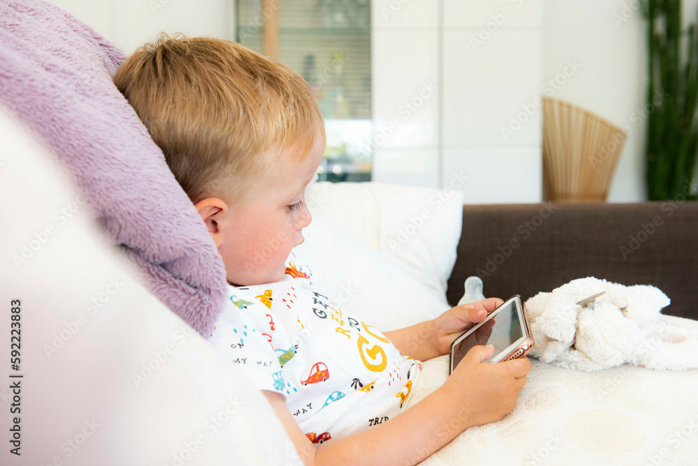 enfant jouant sur un canapé avec un smartphone, style de vie, technologie, enfant jouant sur un canapé avec un smartphone, style de vie, technologie,