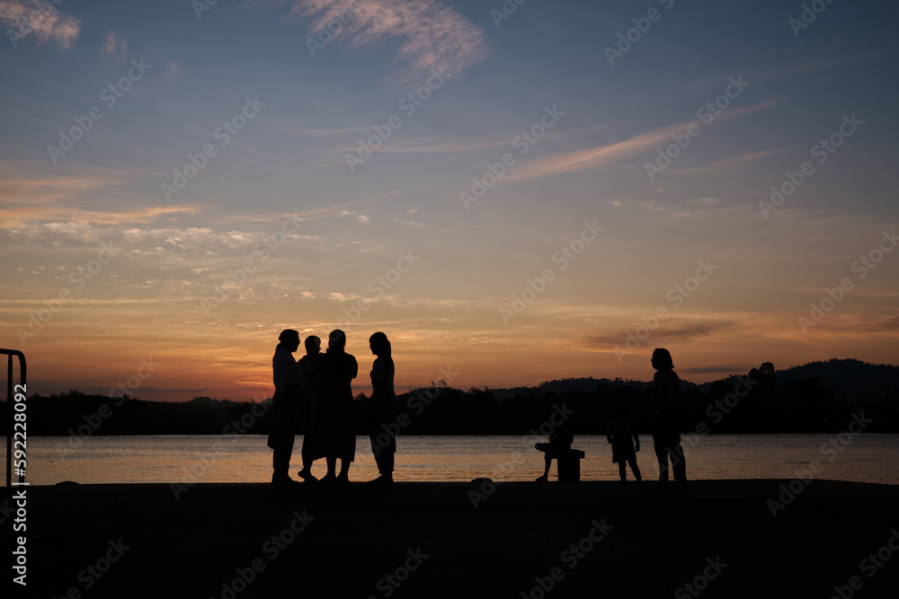 Silhouette of people standing on the port during sunset. Lifestyle, way of life concept