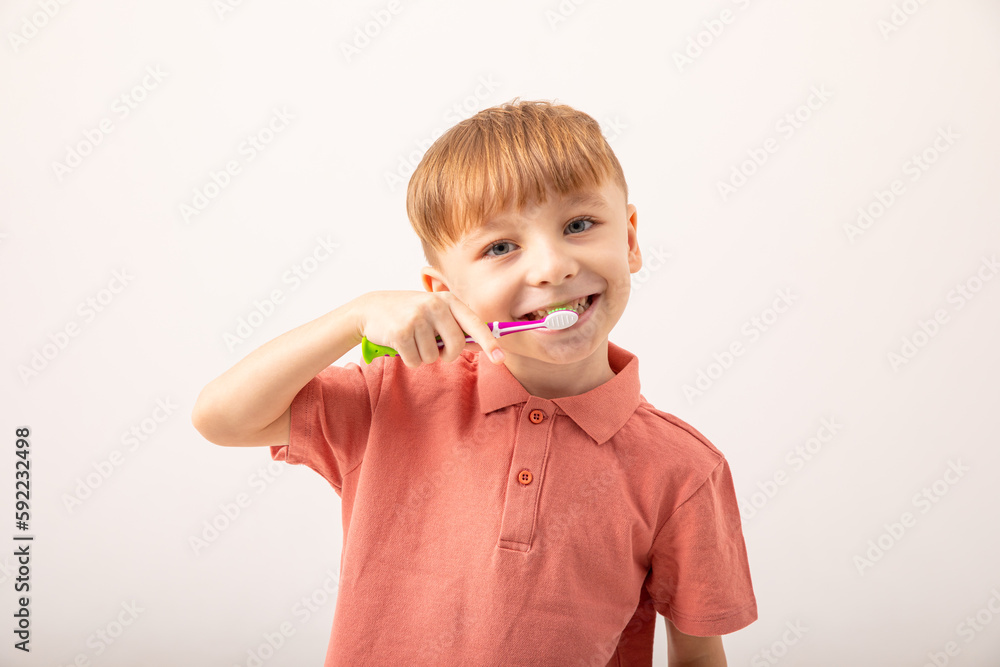 Happy child kid boy brushing teeth with toothbrush on white background. Health care, dental hygiene. Mockup, copy space Happy child kid boy brushing teeth with toothbrush on white background. Health care, dental hygiene. Mockup, copy space