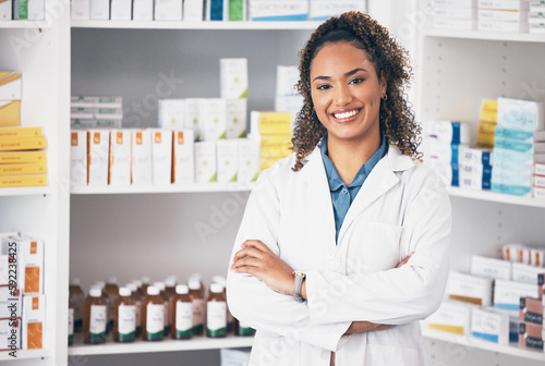 Pharmacy, pharmacist or portrait of woman with arms crossed or smile in customer services or clinic. Healthcare help desk, wellness or happy doctor smiling by medication on shelf in drugstore