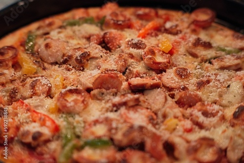 Closeup shot of a delicious deep dish pizza with meat and vegetable toppings