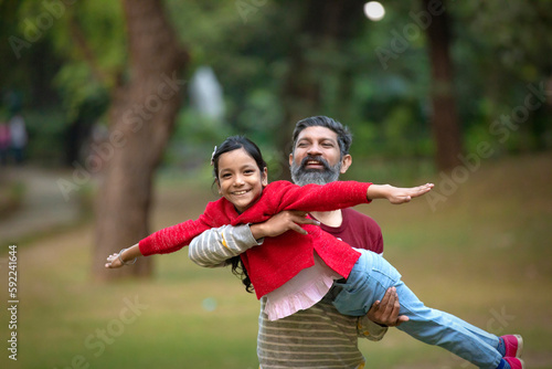 Indian man playing with his daughter at park