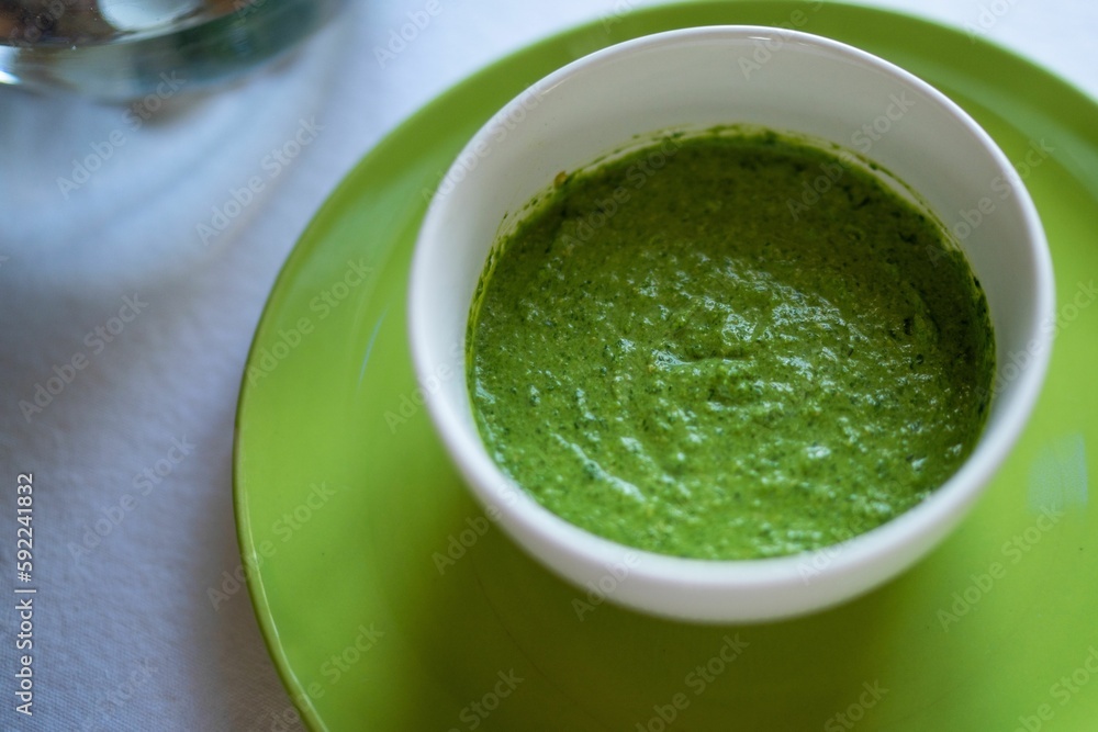 Spinach and pea cream soup served in green bowl, close-up Spinach and pea cream soup served in green bowl, close-up