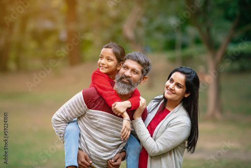 Happy indian couple with his little girl at garden. © PRASANNAPIX