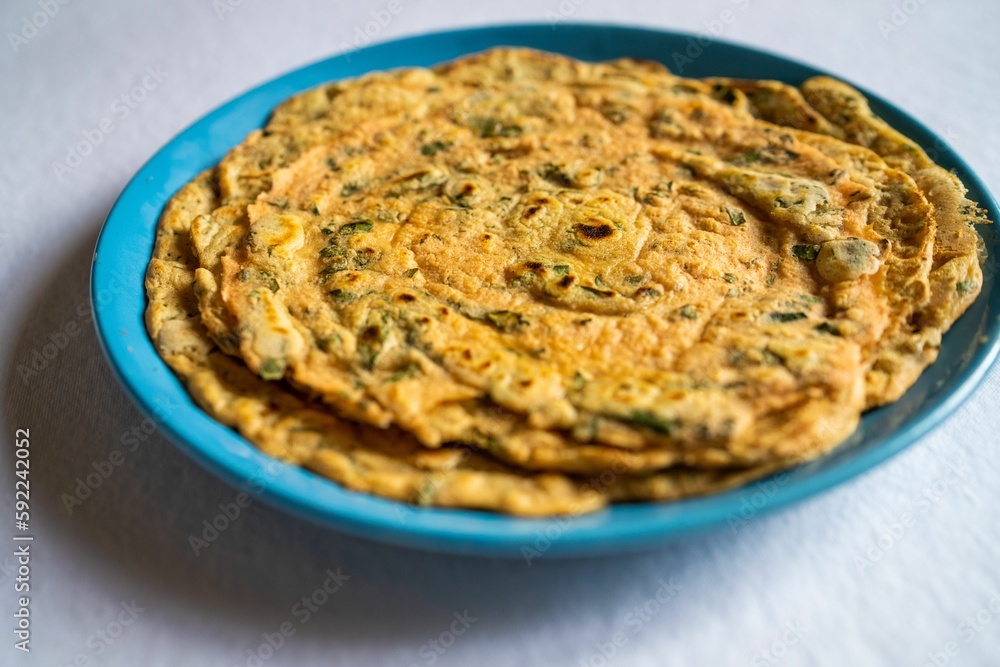 Indian inspired lentil crepe served on a blue plate, close-up Indian inspired lentil crepe served on a blue plate, close-up