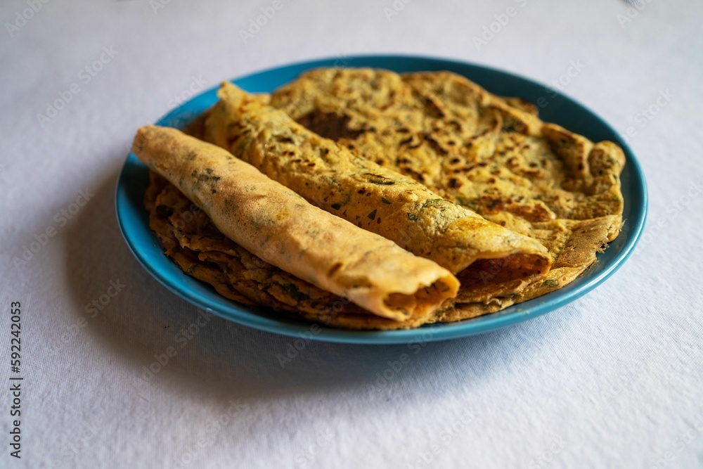 Indian inspired lentil crepe served on a blue plate, close-up Indian inspired lentil crepe served on a blue plate, close-up
