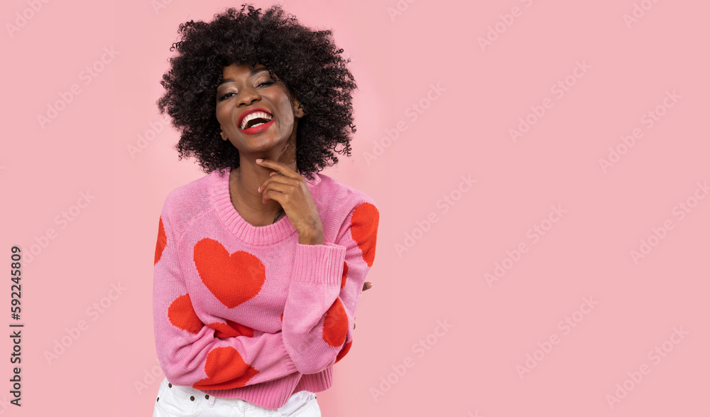Lovely african woman in heart sweater on pink background.