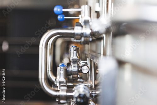 Beer brewing . Commercial brewing equipment close up shot. Industrial beer brewing stainless pipe © Rokas