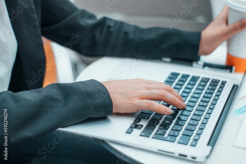 Caucasian woman working in an office with a laptop - a closeup shot of her hands