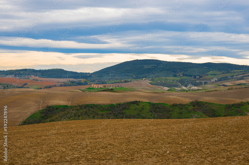Beautiful Italian Landscape in Tuscany with plowed fields and cloudy sky. Pastoral landscape of Tuscany.