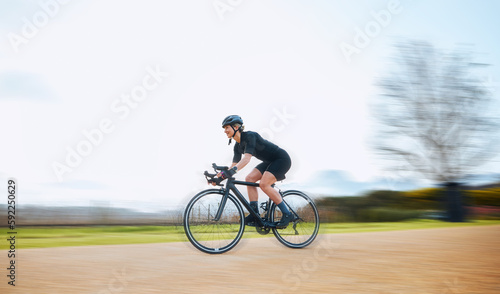 Cycling, motion blur and fitness with woman in nature and mockup for speed, workout and challenge. Exercise, fast and travel with female cyclist riding on bike for journey, adventure and cardio