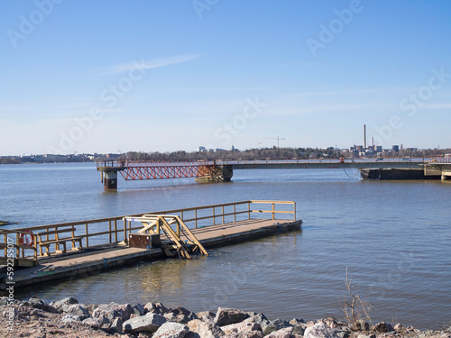 Piers at Kruunuvuori shore in Helsinki, a pier for winter swimmers on the left, Helsinki down town on the horizon, sunny day in April photo