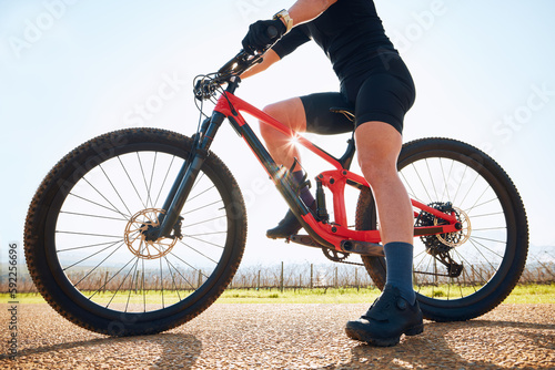 Bicycle, ride outdoor and legs of person on a bike journey for sports race on a gravel road. Fitness, exercise and athlete doing sport training in nature on a countryside trail for cardio and workout