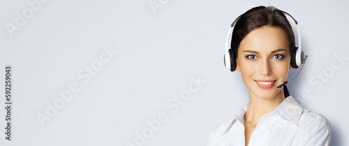 Call center help line service. Studio portrait image of customer support phone sales operator in headset, light grey gray background. Happy smiling business woman. Caller worker.
