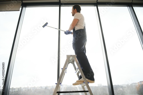 Wallpaper Mural An employee of a professional cleaning service washes the glass of the windows of the building. Showcase cleaning for shops and businesses. Torontodigital.ca