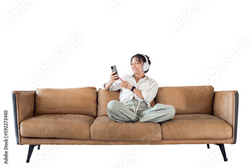 A woman is sitting on the couch using a phone audiobook resting listening to music with headphones, transparent background, isolated.