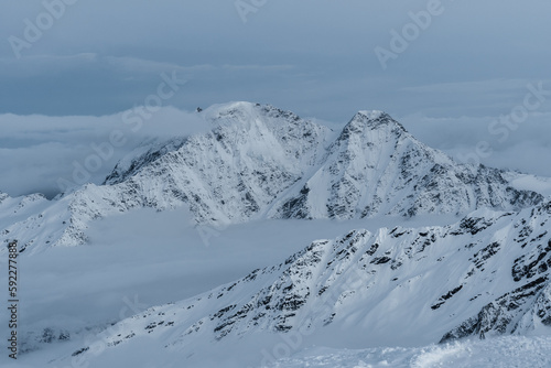 Snowy mountains in the clouds. Beautiful landscape with snowy rocks © Maksim