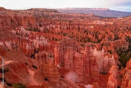 Panoramic morning sunrise view on sandstone rock formations on Navajo Rim hiking trail in Bryce Canyon National Park, Utah, UT, USA. Golden hour colored hoodoo rocks in unique natural amphitheatre