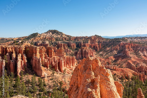 Scenic aerial view on sandstone rock formations on Navajo Rim hiking trail in Bryce Canyon National Park, Utah, USA. Looking on hoodoo rocks in unique natural amphitheatre on sunny blue sky summer day