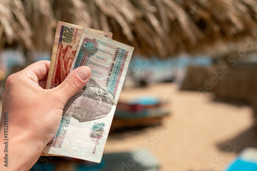 Egyptian pounds in a man's hand on the background of the beach. Egyptian money