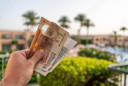 Egyptian pounds in a man's hand on the background of the beach. Egyptian money