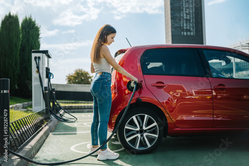 Woman charging electric car in station