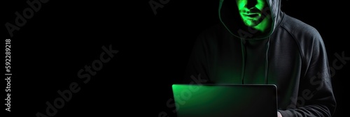 Hacker without face in a hood holds a laptop. on a dark background. Banner for cyber security.  Internet web hack technology. Digital laptop in hacker man hand isolated on black. Generate AI.