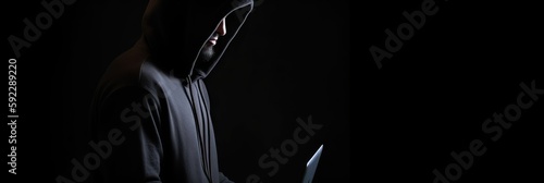 Hacker without face in a hood holds a laptop. on a dark background. Banner for cyber security.  Internet web hack technology. Digital laptop in hacker man hand isolated on black. Generate AI. © Artem