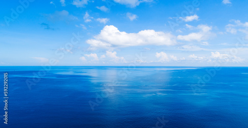 Aerial view of a blue sea surface water texture background and sun reflections,Aerial flying drone view Waves water surface texture on sunny tropical ocean landscape,Nature background © panya99