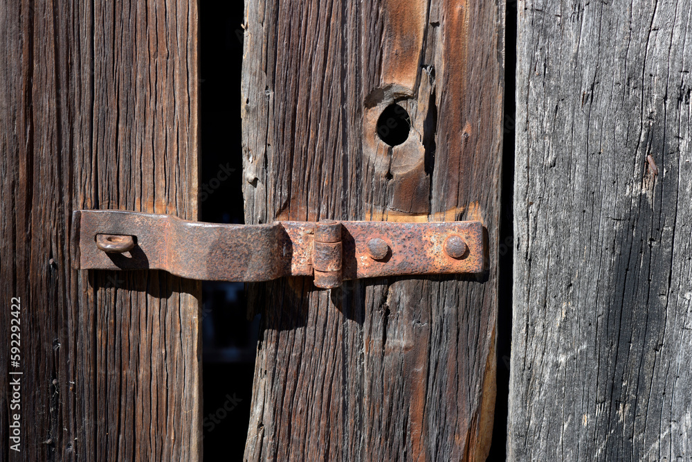 old unpainted wooden gate with rusty hardware old unpainted wooden gate with rusty hardware