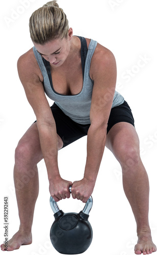 Serious muscular woman lifting kettlebell 