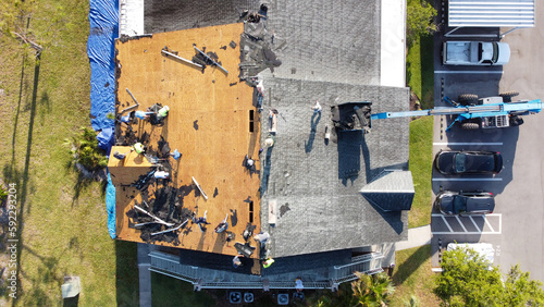Workers repairing a roof damaged by Hurricane Ian in Fort Myers, FL