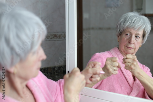 Tableau sur toile Senior woman ready to fight her mirror reflection