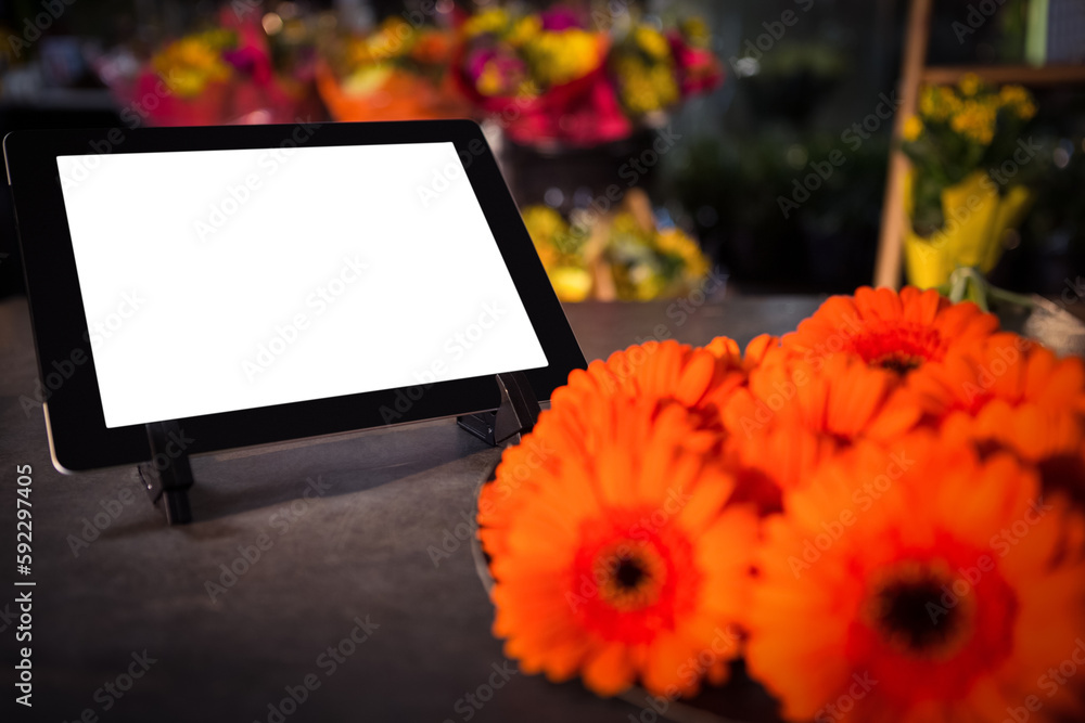 Fresh flowers against digital tablet Fresh flowers against digital tablet
