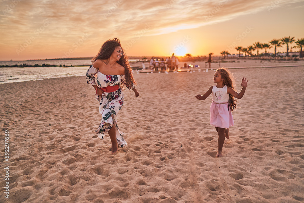 Mother and daughter playing and having fun on the beach Mother and daughter playing and having fun on the beach