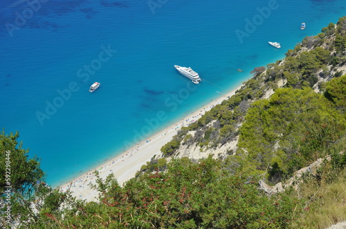 Looking down at a beach full of people in the summer in Greece