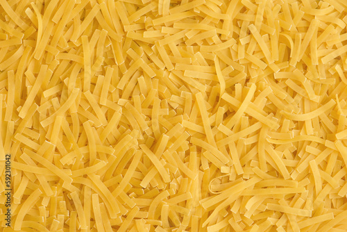 Yellow background with raw vermicelli noodles. Concept - pasta as background.