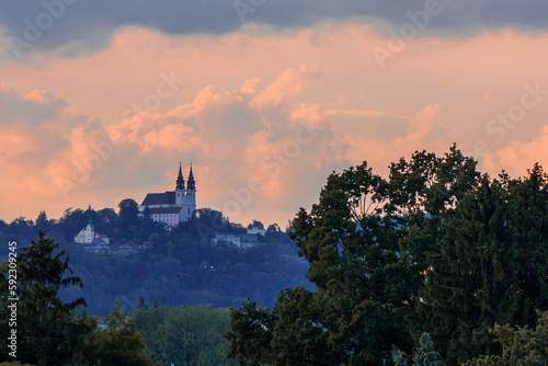 Postlingberg pilgrimage church on a high hill in front of a dramatic pink sky  Austria