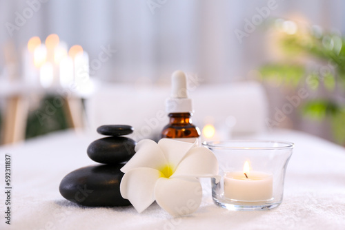 Massage room concept. Stone therapy attributes for cosmetic procedures on a massage table. Symbolic objects for spa salon. Close up, copy space for text, top view, background.