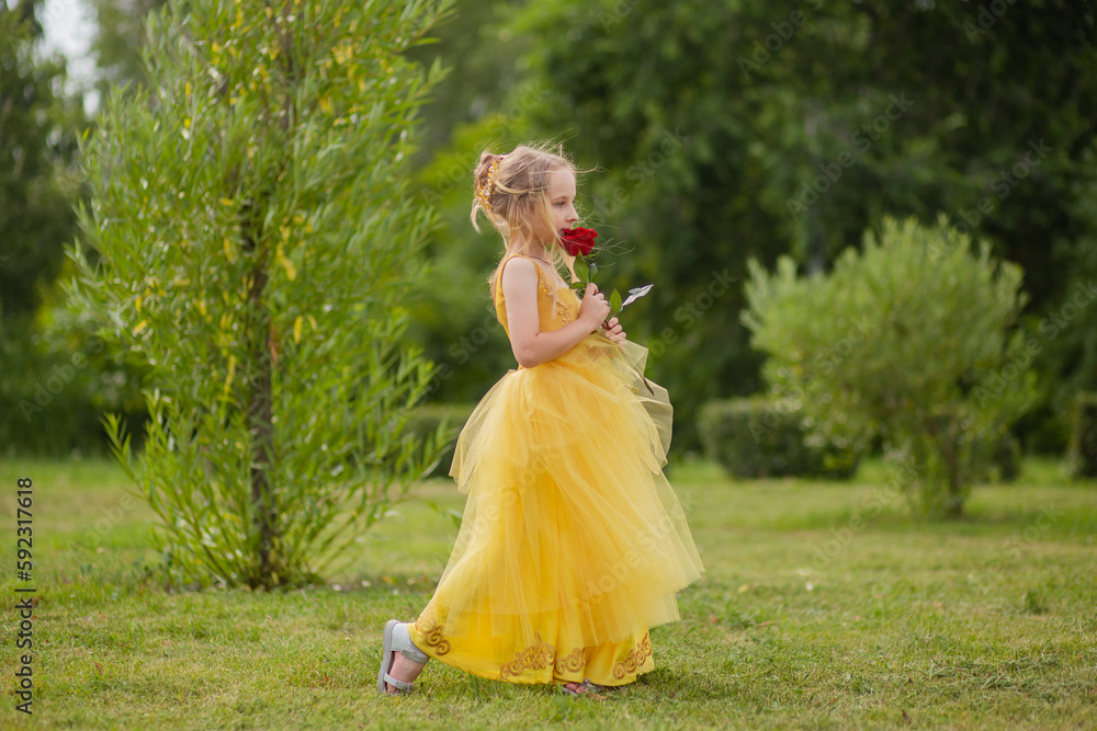 Little Girl In A Yellow Fairy Dress With A Rose In Her Hands. The ...