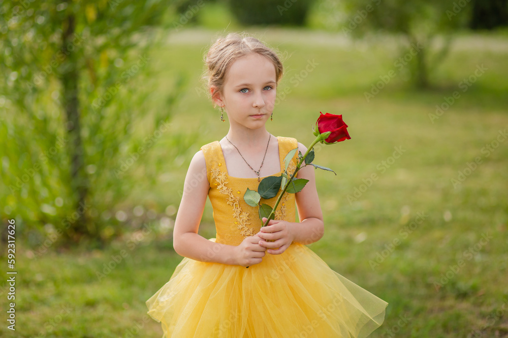 Little girl in a yellow fairy dress with a rose in her hands. The